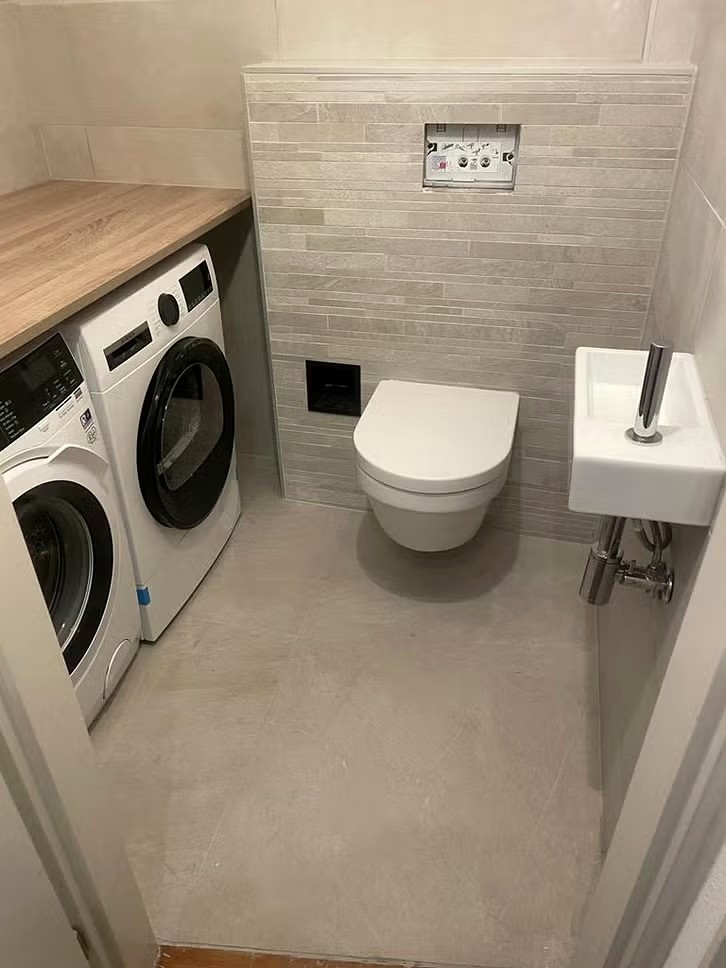 Gerenoveerd toilet met wasmachine en droger